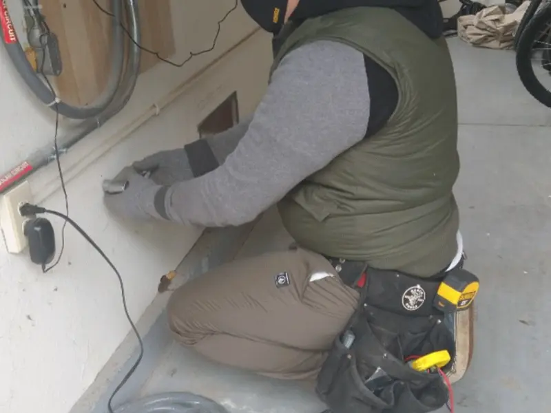 Electrician performing outlet wiring in a Brecknock garage